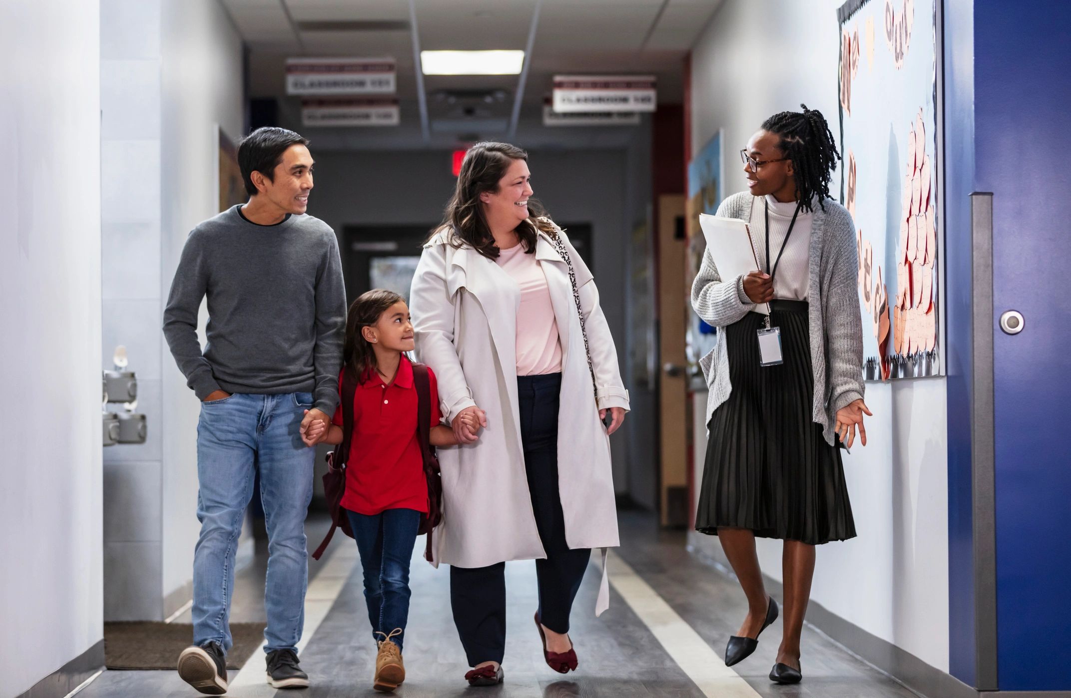 Parents and child connecting with a teacher at school