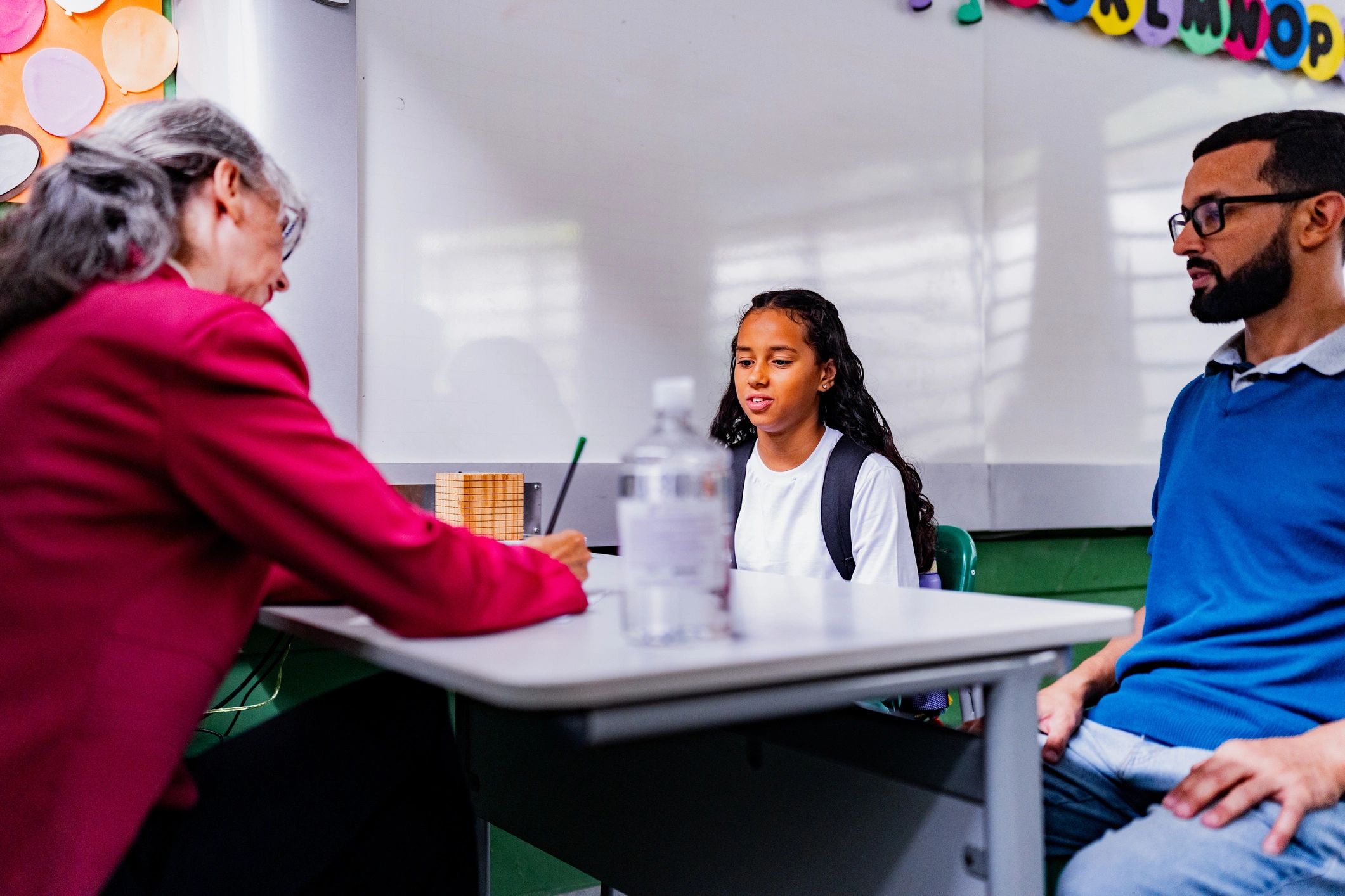 Parent and school principal meeting with a student